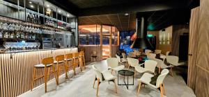 a restaurant with a bar with white chairs and tables at Invisible Forest Lodge & Spa in Rovaniemi