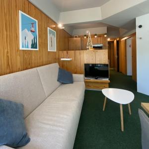 a living room with a couch and a tv at Marilleva1400 Direct Access to Skii Slopes in Mezzana +12 photos