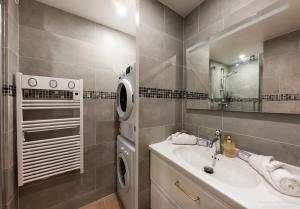 un bagno con lavandino e lavatrice di Saint Raphael appartement 4 étoiles neuf en rez de jardin privatif a Saint-Raphaël Altre 31 foto