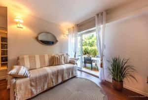 un soggiorno con un divano e una finestra di Saint Raphael appartement 4 étoiles neuf en rez de jardin privatif a Saint-Raphaël