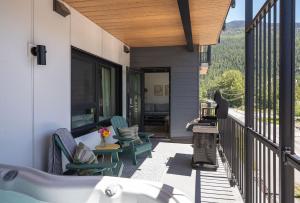 a balcony with chairs and a tub on a house at Cabot Views by Revelstoke Vacations in Revelstoke