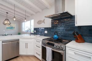 a kitchen with white cabinets and a stove top oven at 304 Ruby Ave B in Newport Beach
