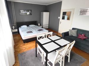 a living room with a bed and a table and chairs at Bálint Apartman - In the heart of Miskolc in Miskolc +21 photos