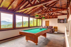 a pool table in a room with windows at При Баръма in Vishnevo