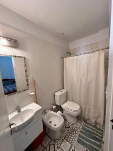 ein Badezimmer mit einer weißen Toilette und einem Waschbecken in der Unterkunft Atardecer Patagónico in Puerto Madryn