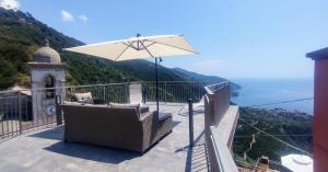 a balcony with a chair and an umbrella at Rosmarino, Cinque Terre in Vernazza