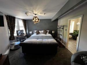 a bedroom with a large bed and a chandelier at Elephant and Castle Boutique Bed & Breakfast in Huddersfield