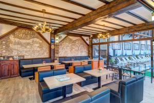 a restaurant with tables and chairs and a wall of windows at При Баръма in Vishnevo