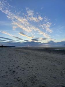- une plage avec un ciel nuageux et l'océan dans l'établissement Appartement Des Lingots, à Honfleur 3 autres photos