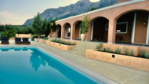 a house with a swimming pool in front of a house at Trabala Ionian Living in Paleros