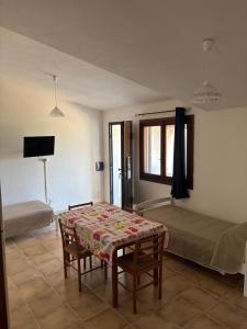 una stanza con un tavolo, un letto e una finestra di Agrustos Paradise a Budoni