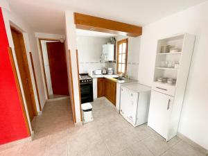 a small kitchen with a stove and a refrigerator at Hermoso departamento en Esquel, amplio y luminoso in Esquel +6 photos
