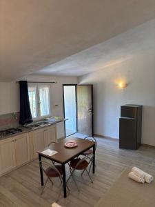 una cucina con un tavolo e una cucina con un frigorifero di Agrustos Paradise a Budoni