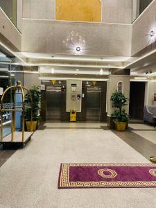 a lobby with two elevators and a rug at Lamasat Al Ajnaha Serviced Apartments in Abha