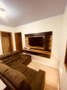 a living room with a couch and a flat screen tv at Sobrado Toledo in São Francisco de Paula
