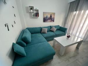 Una sala de estar con un sofá verde y una mesa. en Serres city center modern apartment (Monika), en Serres