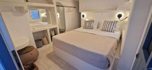 a small bedroom with a bed and a mirror at Naousa's Melody in Naousa