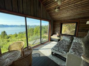a bedroom with a bed and a large window at Forest Hideaway With Scenic View in Fiskå