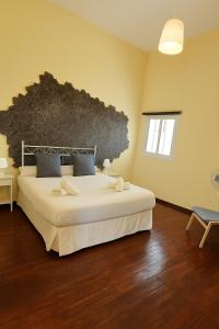 a bedroom with a large bed with a stone wall at Casa Tina in Güimar