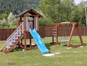 a playground with a blue slide and a gazebo at Карпатський двір in Krivorovnya