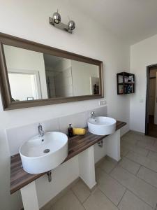 a bathroom with two sinks and a large mirror at Pension Albert - möblierte Einzel- und Doppel- Zimmer auf Zeit in Stuttgart