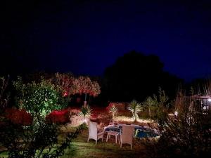スヴォロナータにあるEnjoy The Silenceの夜のプールの横に置かれたテーブルと椅子