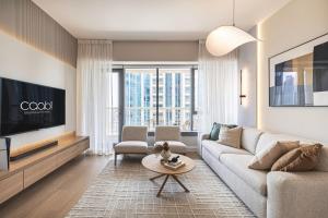 a living room with a couch and a tv at The Burj View Suite Luxury 1BR Full Burj Views in Dubai