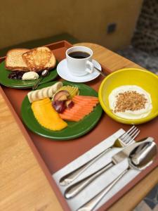 a table with two plates of food and a cup of coffee at Rodona Hotel in Mexico City