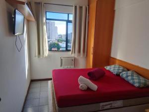 a red bed in a room with a window at Jardim de Alah in Campos dos Goytacazes