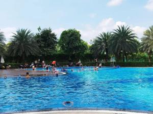 a large swimming pool with people in the water at AnDi's Homestay in Gò Công
