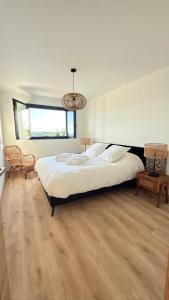 une chambre avec un grand lit et une fenêtre dans l'établissement Maison avec Jacuzzi proche du lac, à Marcillac-la-Croisille