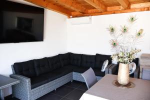 a living room with a black couch and a table at Villa Dalmatia with pool in Slivnica