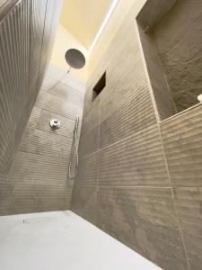 un bagno con doccia con parete in pietra di Bìfara Rooms a Palermo Altre 22 foto