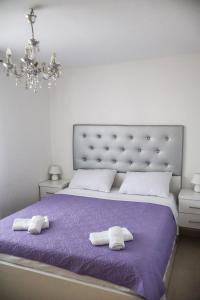 a bedroom with a purple bed with two towels at Villa Dalmatia with pool in Slivnica +22 photos