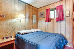 a bedroom with a blue bed and a window at Buckhorn in Iron River with Sauna Fish and Hike! in Iron River