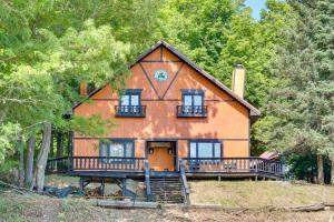 a large orange house with a porch and trees at Buckhorn in Iron River with Sauna Fish and Hike! in Iron River