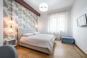 a bedroom with a white bed and a window at Casa Amelia - Elegant Suite [parcheggio gratuito] in Parma