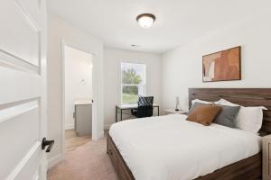 a white bedroom with a large bed and a desk at Arte Luxury Townhomes E2 I Comfy 2 Bed 25 Bath in Oak Grove +17 photos