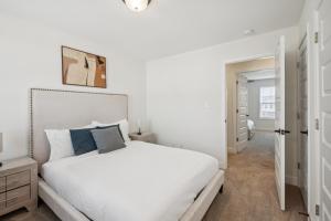 a white bedroom with a white bed with blue pillows at Arte Luxury Townhomes K3 I Comfy 2 Bed 25 Bath in Oak Grove +17 photos