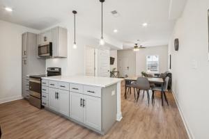 a kitchen with white cabinets and a table with chairs at Arte Luxury Townhomes K3 I Comfy 2 Bed 25 Bath in Oak Grove