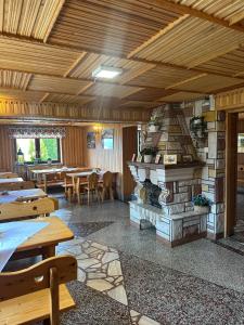 a restaurant with a fireplace in the middle of a room at Pokoje Gościnne Stołowe in Gliczarów Górny