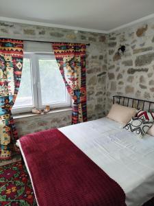a bedroom with a large bed and a window at Čemerno cottage 2 in Gacko +7 photos