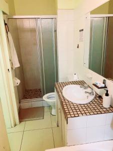 a bathroom with a shower and a sink and a toilet at Frontline Holiday apartment in Durban +7 photos