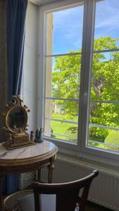 a room with a table and a large window at L'Écrin du Marquis 