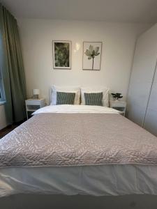 a bedroom with a large white bed with two pillows at Cozy Modern Apartment, 20 mins to Center in Prague