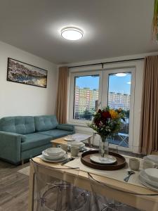 a living room with a couch and a table at Cozy Modern Apartment, 20 mins to Center in Prague