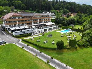 widok z lotu ptaka na hotel z trawnikiem i basenem w obiekcie Dei Hotel Schönblick w mieście Velden am Wörthersee