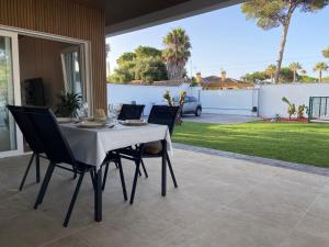 a table and chairs sitting on a patio at Mi Huerto, Casa con piscina, en la Barrosa in Chiclana de la Frontera