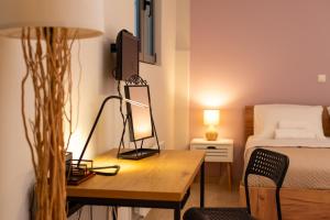 a bedroom with a bed and a desk with a mirror at Sofi's Cozy House Near Athens Airport in Artemida