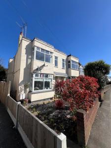 a white house with a fence in front of it at Salvation View 2 Bed Apartment in Hadleigh